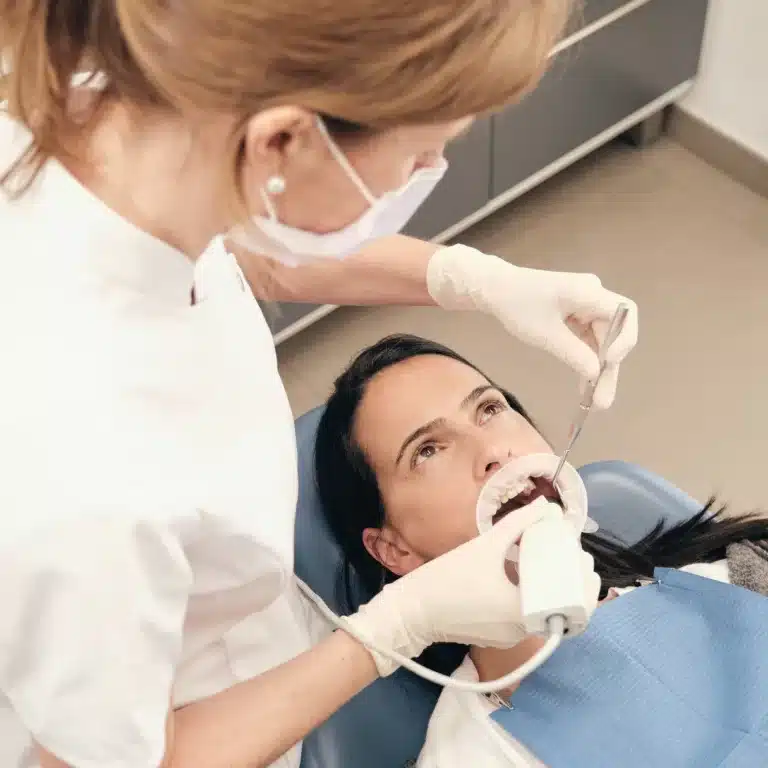 Female dentist scanning teeth of woman